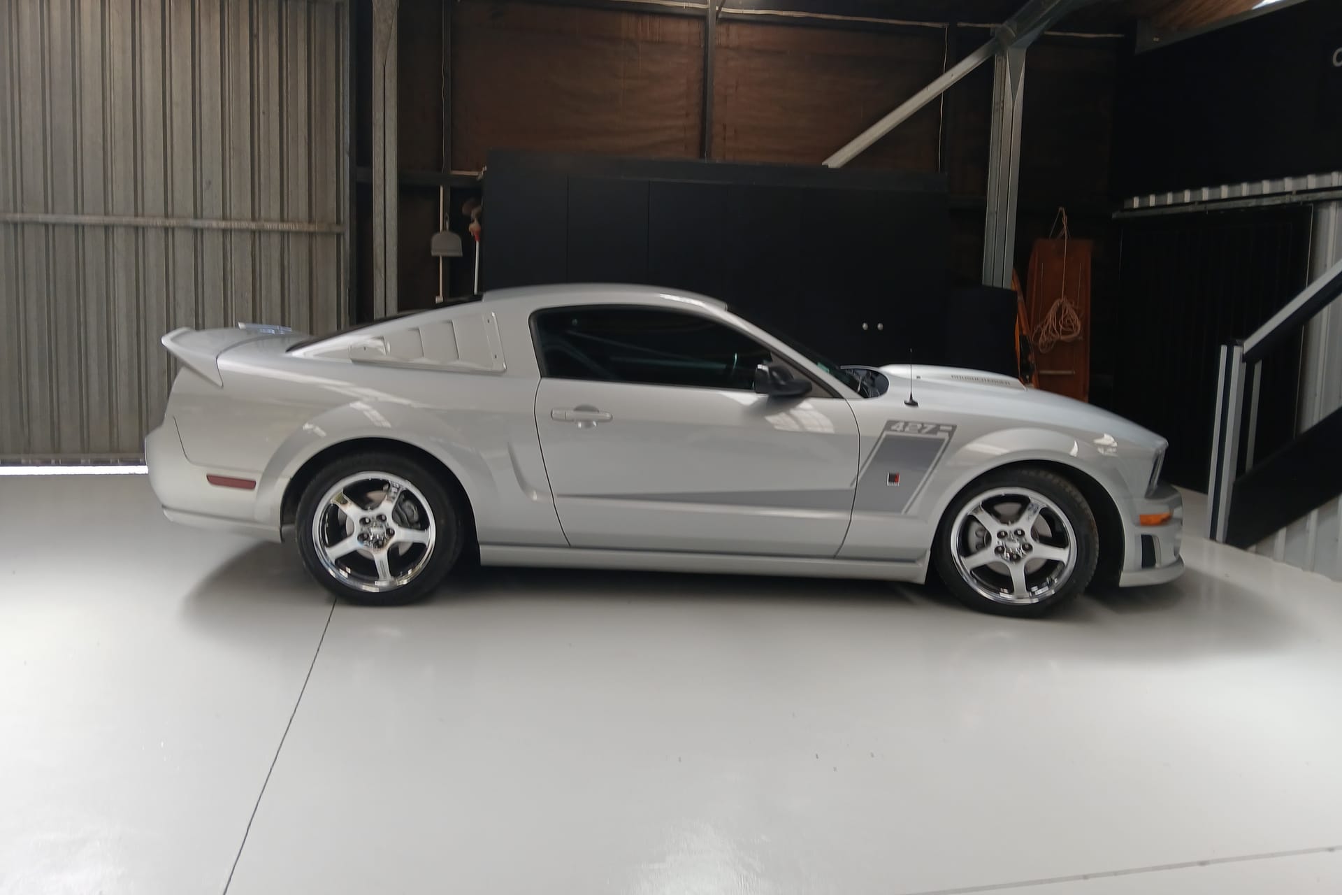 Side view of the silver 2007 427R Roush Mustang in the workshop